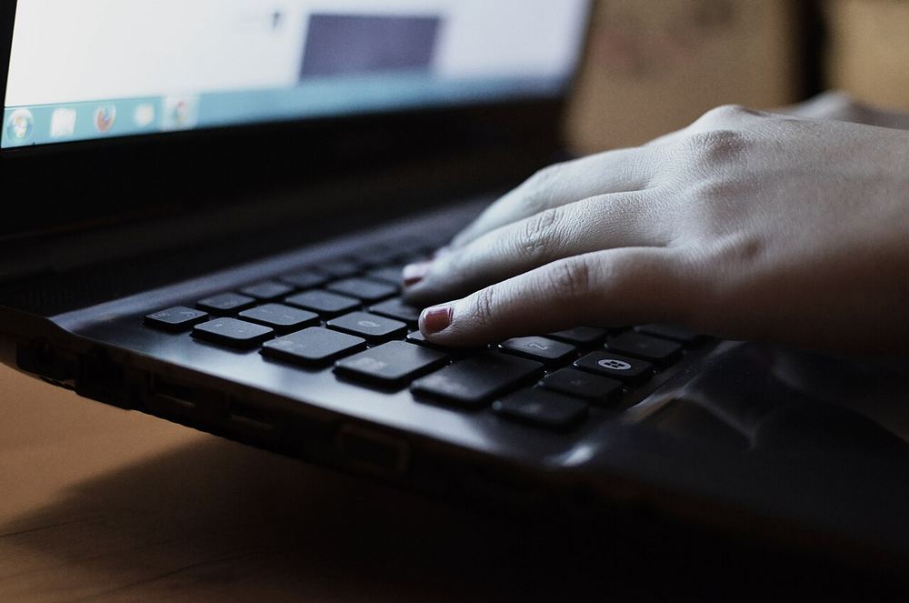 Persona trabajando con un portátil y una libreta